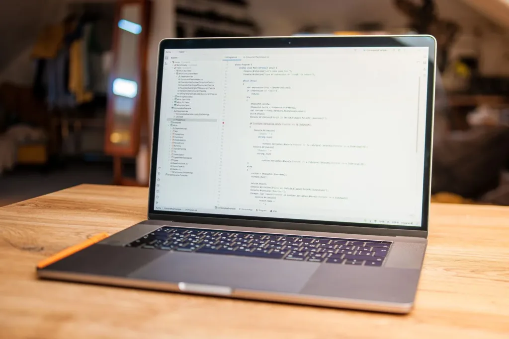Laptop displaying code on a wooden desk