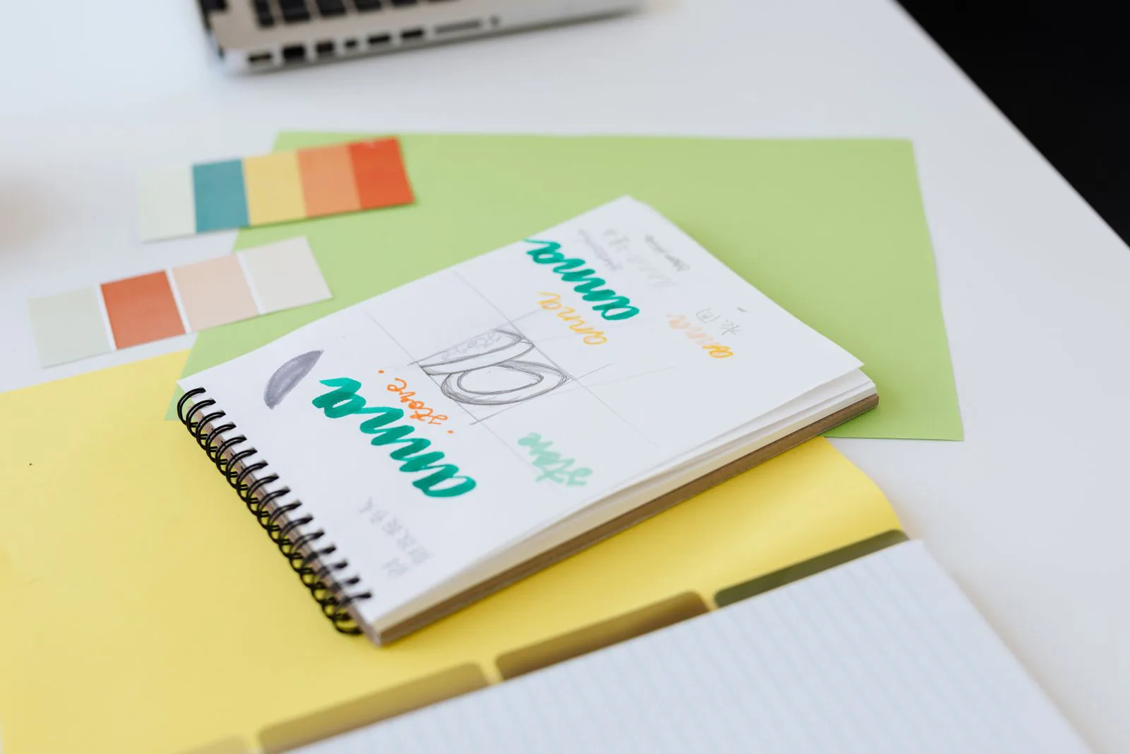 Notebook with logo sketches and colour swatches